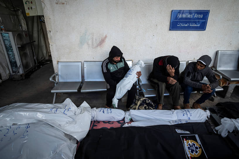 Палестинцы оплакивают родственников, погибших в результате бомбардировки сектора Газа в Рафахе