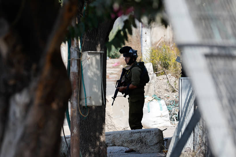 Израильский солдат охраняет улицу в закрытом на въезд Хевроне 