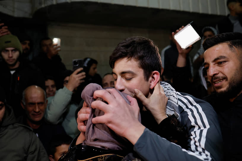 Освобожденный палестинский заключенный целует мать по возвращению домой 