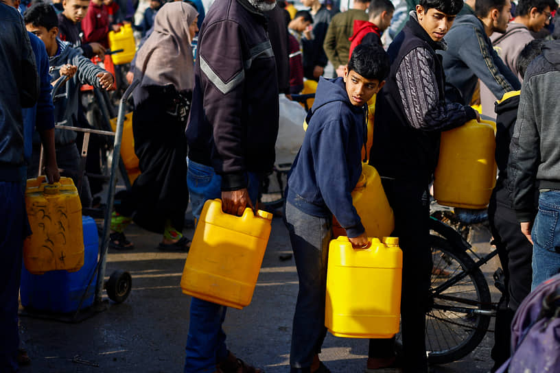 Палестинские дети стоят в очереди за питьевой водой на юге сектора Газа