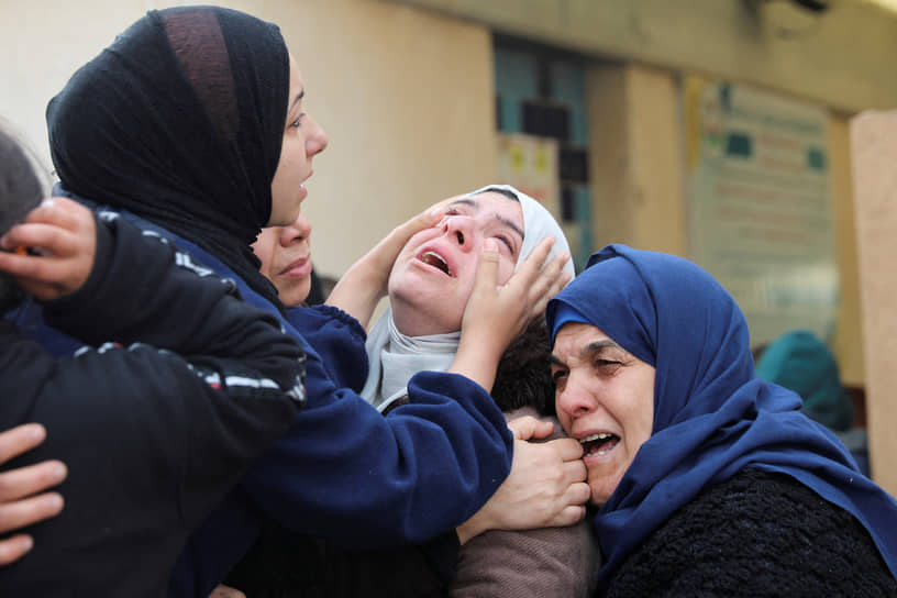Родственники на похоронах палестинцев, погибших в результате ракетного удара на юге сектора Газа