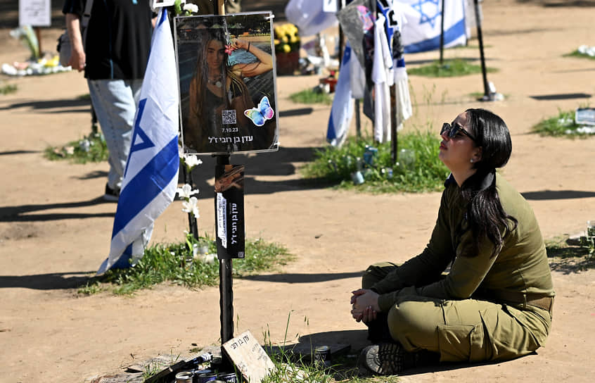 Израильский солдат смотрит на фотографии людей, убитых 7 октября 2023 года, на месте проведения музыкального фестиваля «Нова» рядом с кибуцем Реим