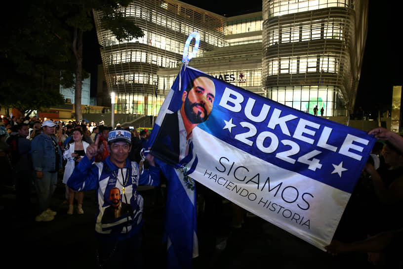 Мужчина держит предвыборный флаг с изображением президента Сальвадора Наиба Букеле 