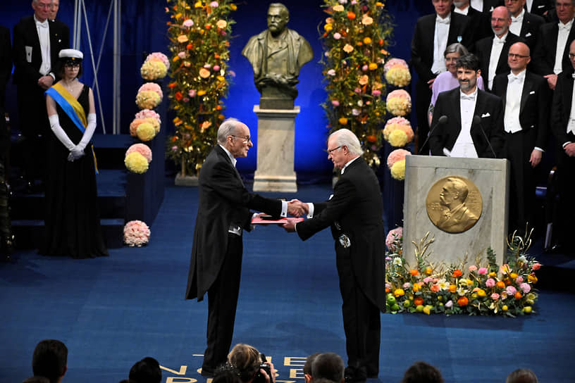 Король Швеции Карл XVI Густав вручает Нобелевскую премию по химии американскому ученому Луи Брюсу. Он получил награду вместе с Мунги Бавенди и Алексеем Екимовым за «открытие и синтез квантовых точек»