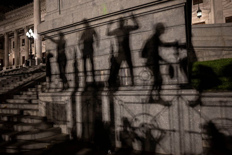 Буэнос-Айрес, Аргентина. Тени демонстрантов, протестующих против нового правительства, на здании Национального конгресса