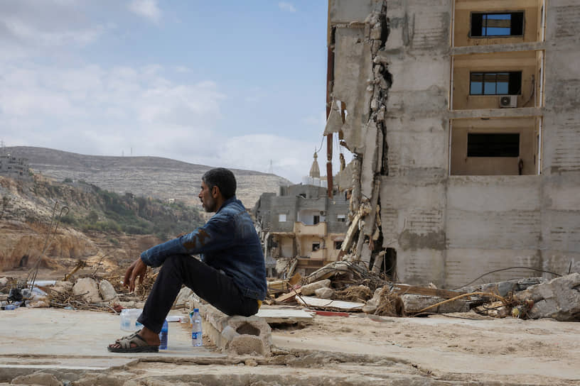 Мужчина сидит у дома, разрушенного наводнением. Дерн, Ливия, сентябрь 2023 года.