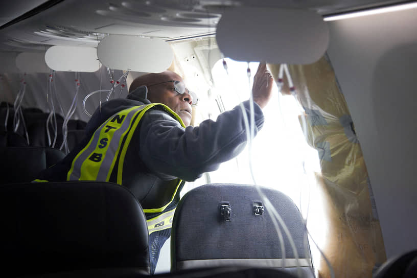 Специалист Национального совета по безопасности на транспорте осматривает повреждение фюзеляжа Boeing 737-9 MAX