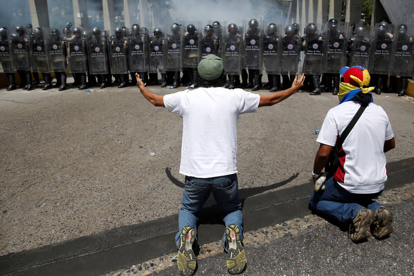 Протестующие стоят на коленях перед силовиками, март 2014 года
