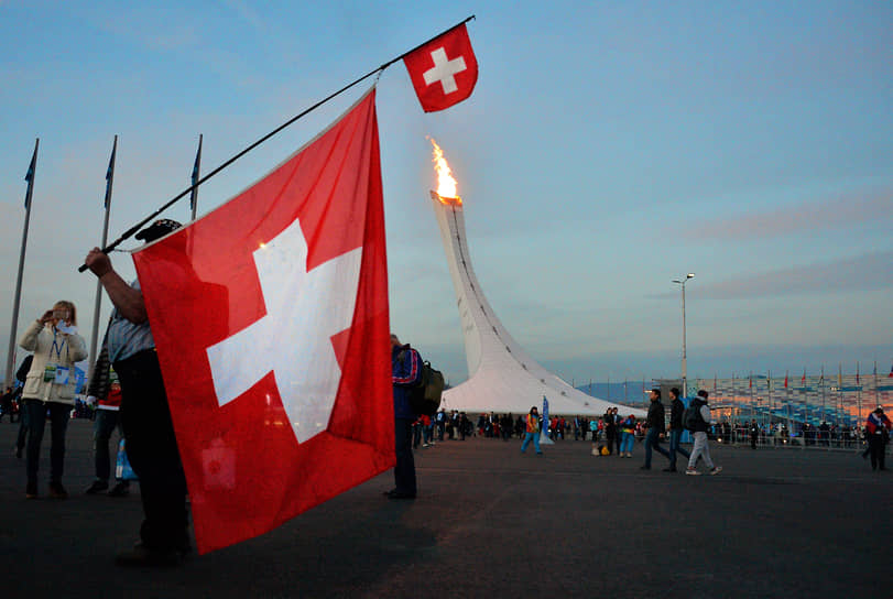 Мужчина держит флаг Швейцарии 