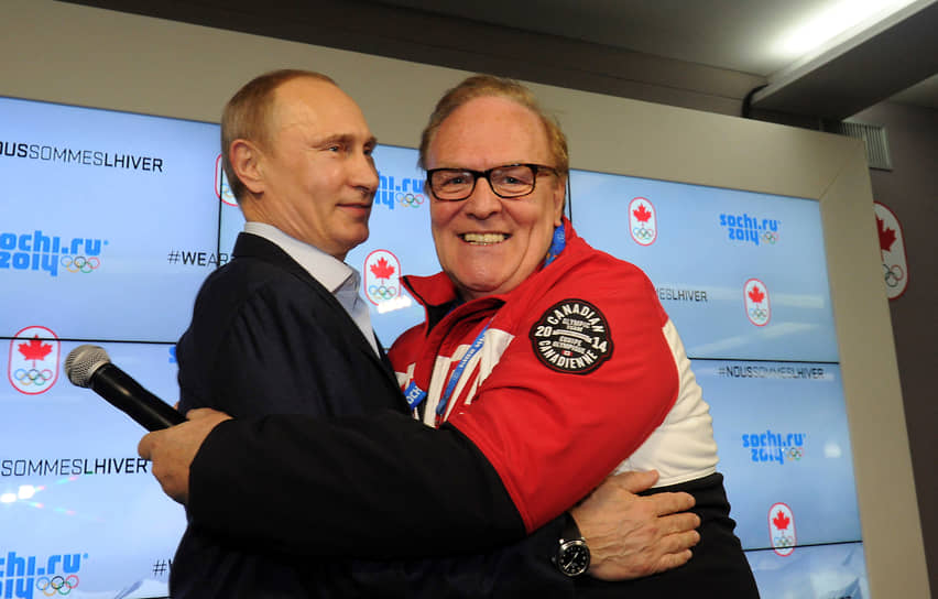 Президент России Владимир Путин (слева) обнимает главу Олимпийского комитета Канады Марселя Обю