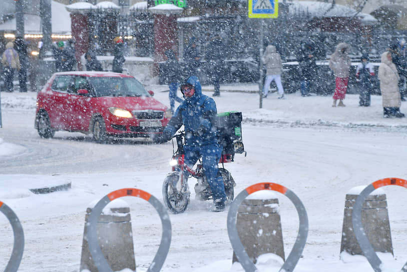 Курьер едет по заснеженной дороге в Москве