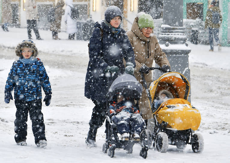 Женщины с колясками во время снегопада в Москве
