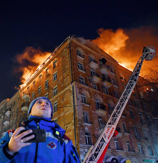 Москва. Сотрудник пожарной службы МЧС на фоне горящего дома на улице Черняховского