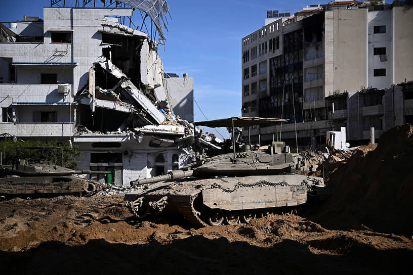 Израильский танк на фоне разрушенного дома в Газе