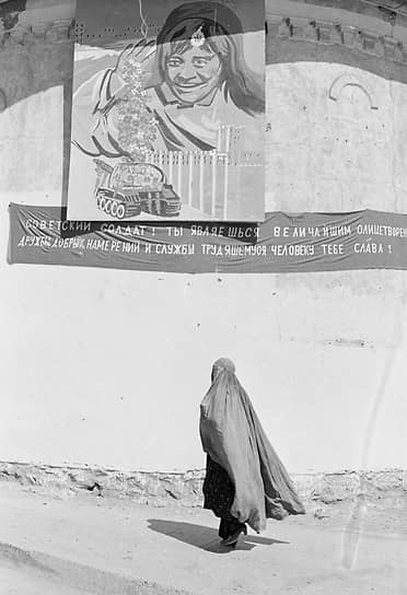 Женщина в парандже на фоне плаката «Спасибо нашим советским друзьям и до свидания»