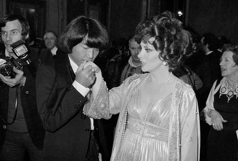 Кэндзо Такада целует руку итальянской актрисы Джины Лоллобриджиды после того, как она вручила ему премию как одному из десяти самых элегантных мужчин в мире (Рим, декабрь 1977 года)