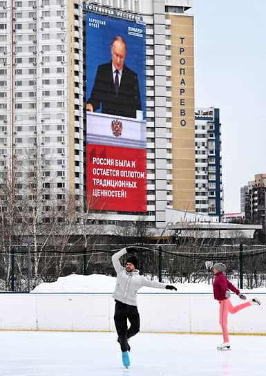 Москва. Люди катаются на коньках на фоне трансляции с президентом 