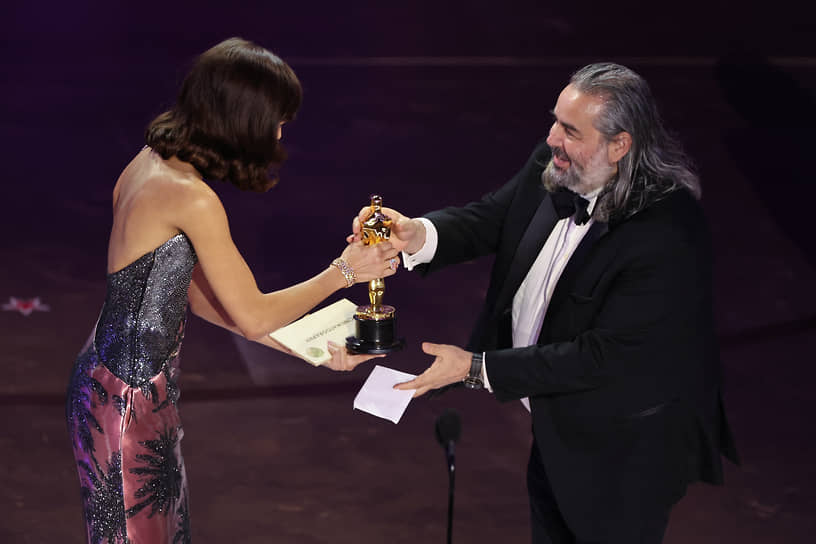 Актриса Зендея вручает Хойту ван Хойтеме «Оскар» за лучшую операторскую работу за фильм «Оппенгеймер»