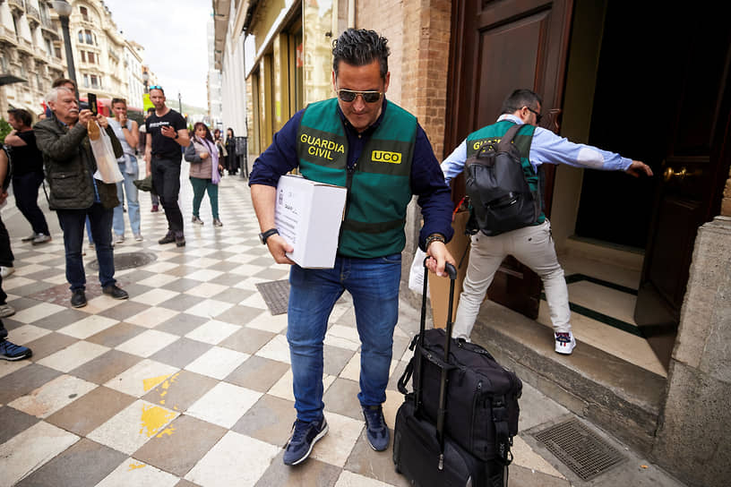 Сотрудник гражданской гвардии выносит документы после обыска в доме Рубиалеса в Гранаде (март 2024 года)