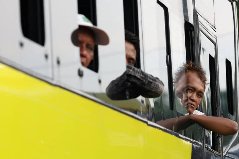 Джакарта, Индонезия. Пассажиры смотрят в окно автобуса