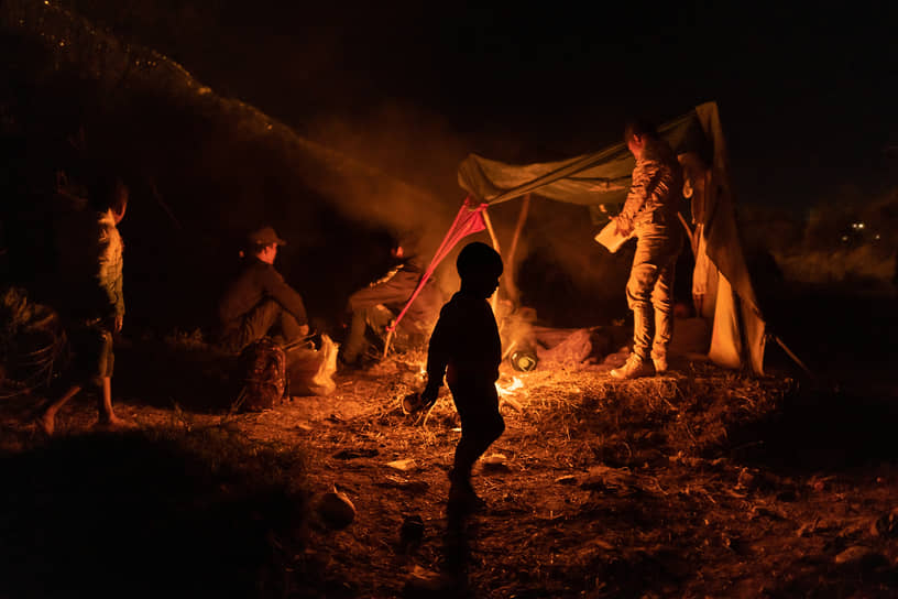 Эль-Пасо, США. Семья мигрантов из Колумбии разжигает костер на берегу реки Рио-Гранде 