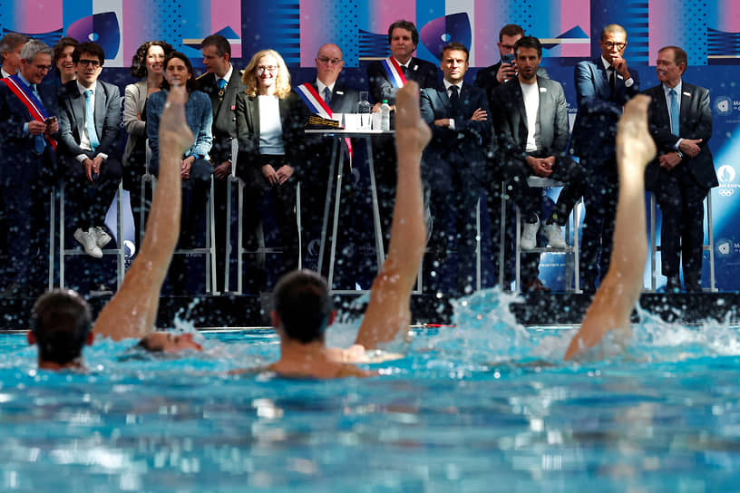 Сен-Дени, Франция. Председатель Организационного комитета по проведению Олимпиады 2024 года в Париже (третий справа) и президент Франции Эмманюэль Макрон (четвертый справа) наблюдают за выступлением по синхронному плаванию на открытии Олимпийского центра водных видов спорт