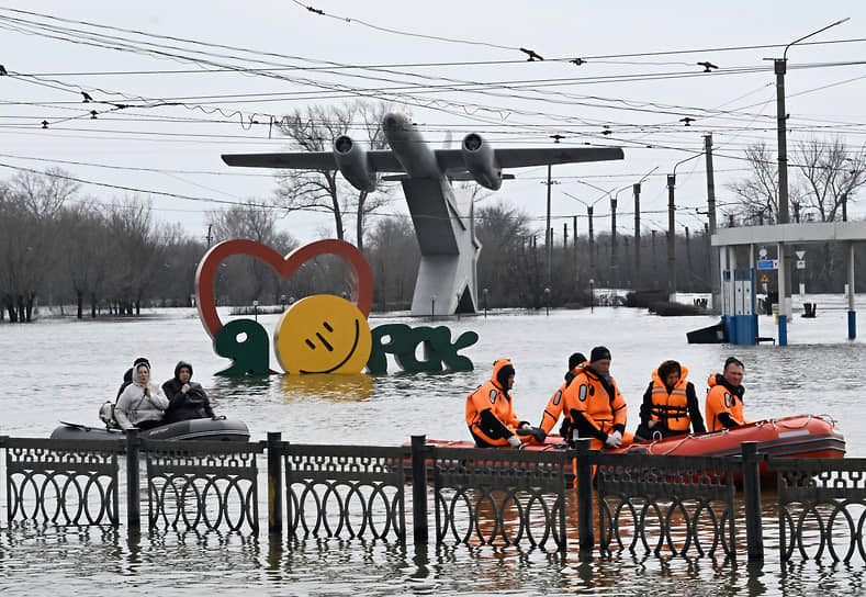 Сотрудники МЧС и жители Орска на лодках на фоне памятника самолету Ил-28 