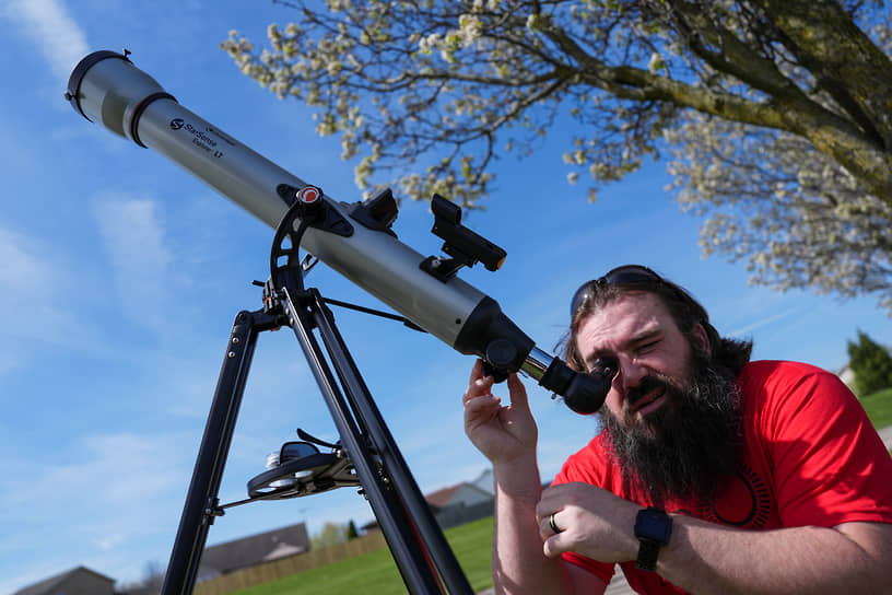 Мужчина настраивает телескоп перед затмением в Солоне (США)