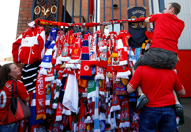 Болельщики «Ливерпуля» повязывают клубные шарфы на ворота перед началом поминальной службы