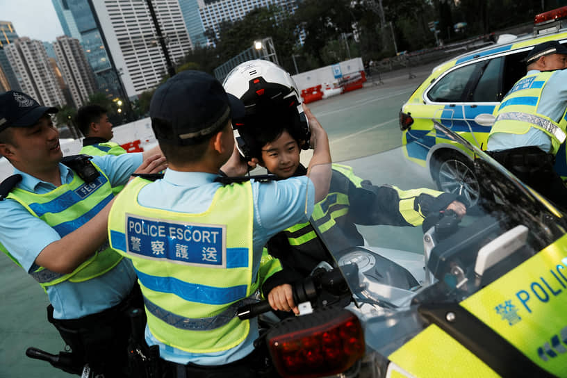 Гонконг, Китай. Школьник на полицейском мотоцикле во Всенародный день просвещения в области национальной безопасности