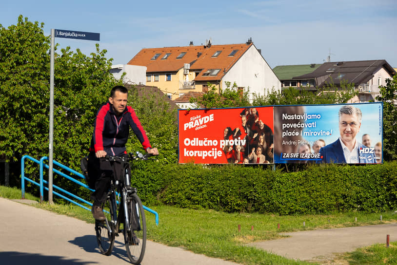 Велосипедист на фоне билбордов в поддержку кандидатов на выборы. Загреб, 15 апреля 2024 года