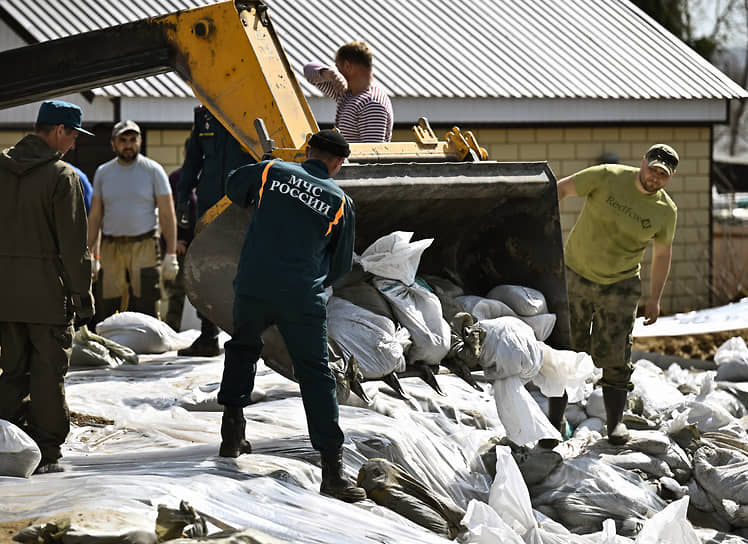 Сотрудники МЧС России и волонтеры возводят защитные сооружения из мешков с песком