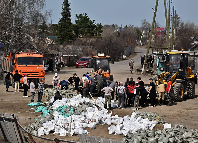 Сотрудники МЧС России и местные жители во время работ по возведению защитных сооружений