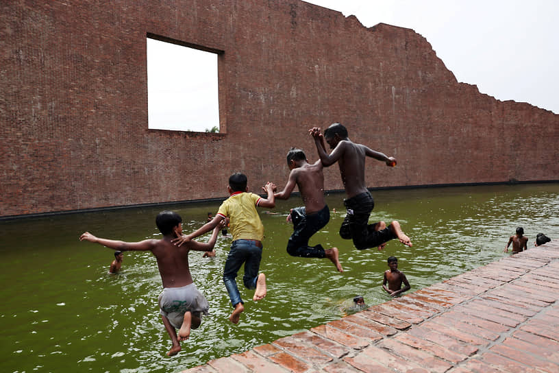 Дакка, Бангладеш. Дети прыгают в водоем Мемориала замученных интеллектуалов