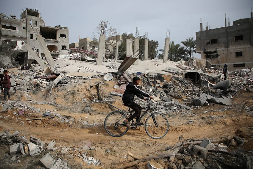 Палестинцы на развалинах зданий в Рафахе (март 2024 года)