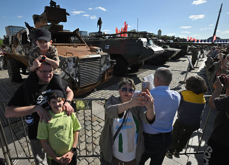 Посетители выставки фотографируются на фоне австралийского бронеавтомобиля Bushmaster