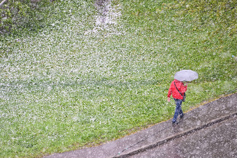 Москва. Человек идет под зонтом во время снегопада 