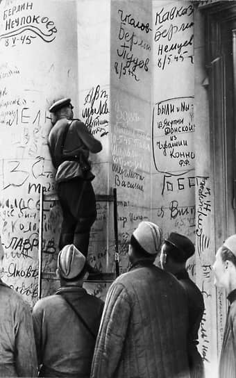 Советский офицер расписывается на стене Рейхстага