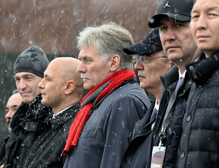 Пресс-секретарь президента России Дмитрий Песков (в центре) наблюдает за парадом на Красной площади