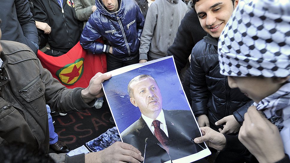 Турецкие курды грозят разорвать перемирие с Анкарой, если премьер Реджеп Тайип Эрдоган (на фото — его портрет в руках у демонстрантов) откажется расширять их права 