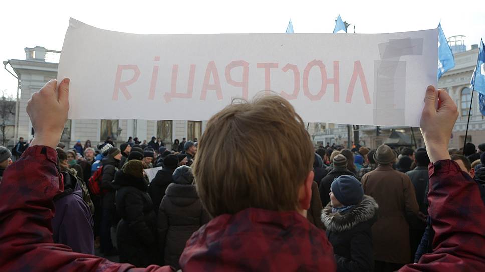 Человек держит плакат с надписью: &amp;quot;Люстация&amp;quot; под стенами Верховной рады Украины во время заседания