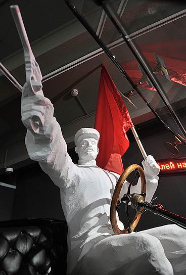 Гипсовый большевик на «Форде», размахивая пистолетом и знаменем, символизирует пришествие нового мира без руля и без ветрил 