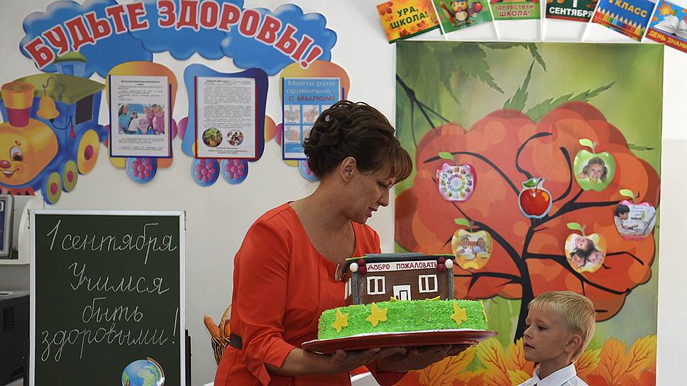 Празднование Дня знаний в школе города Кореновск. Учительница держит праздничный торт для учеников