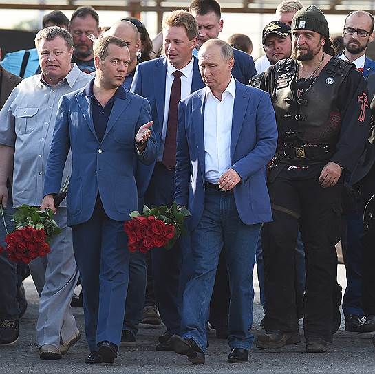 Владимир Путин и Дмитрий Медведев направляются к мемориалу героям 35-й береговой батареи в сопровождении губернатора Дмитрия Овсянникова (в центре за ними) и лидером «Ночных волков» Хирургом (справа)