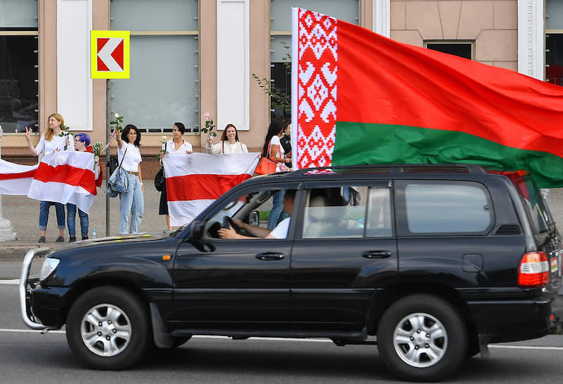 На улицах Минска в пятницу развернулась «война флагов»: сторонники Александра Лукашенко ездили с красно-зелеными, оппозиционеры стояли в цепи с бело-красно-белыми