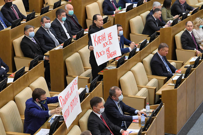 Член комитета Госдумы по культуре Иван Мусатов (в центре) держит плакат с надписью «Кабан не лось, лось не кабан»
