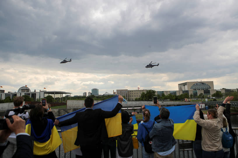 Зрители наблюдают, как президент Украины покидает покидает ведомство федерального канцлера на вертолете