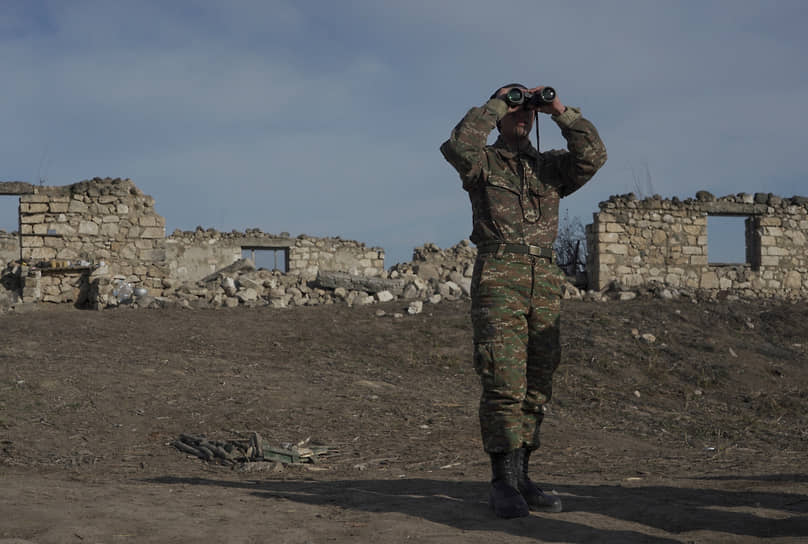 Армянский солдат смотрит в бинокль на позиции в Нагорном Карабахе
