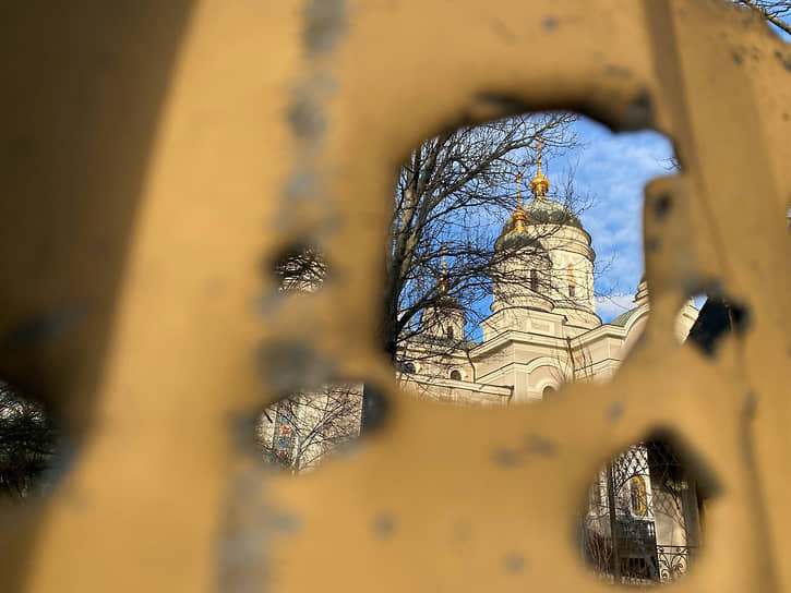 Свято-Преображенский собор сквозь отверстие от попадания снаряда в ограде