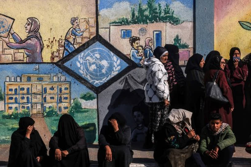 Палестинцы стоят в очереди за гуманитарной помощью